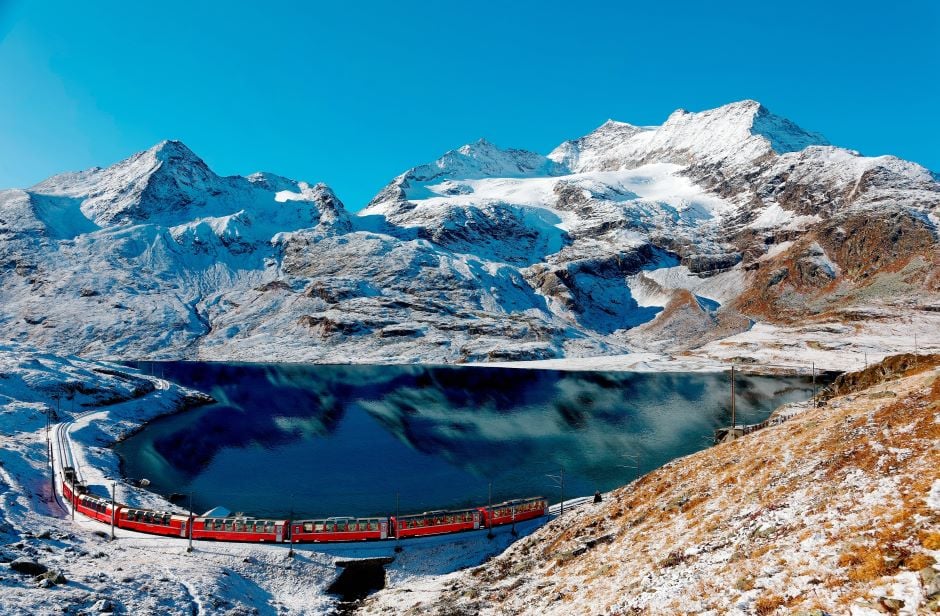 bernina express passing by snowy mountain