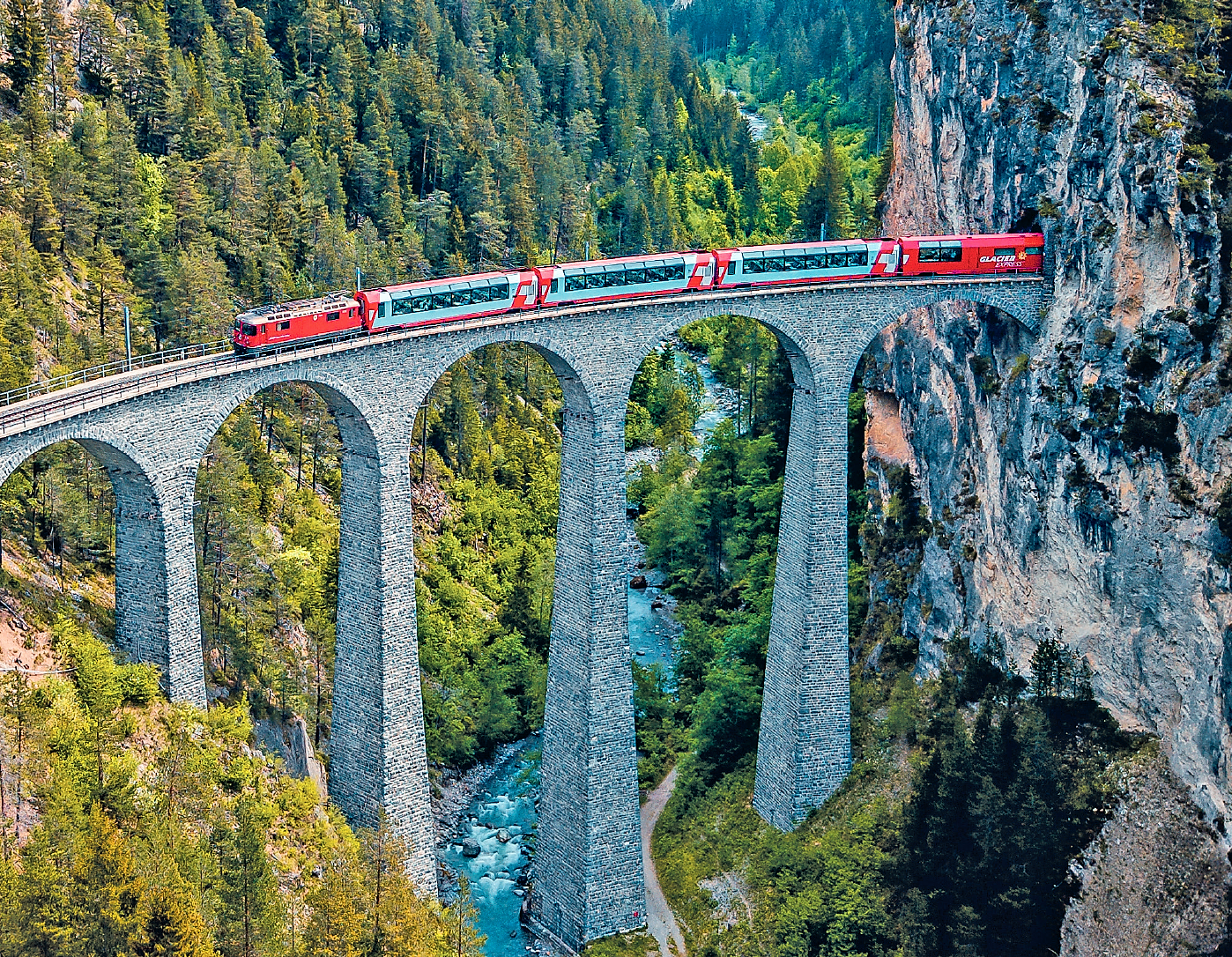 bernina express passing through tunnel and over bridge