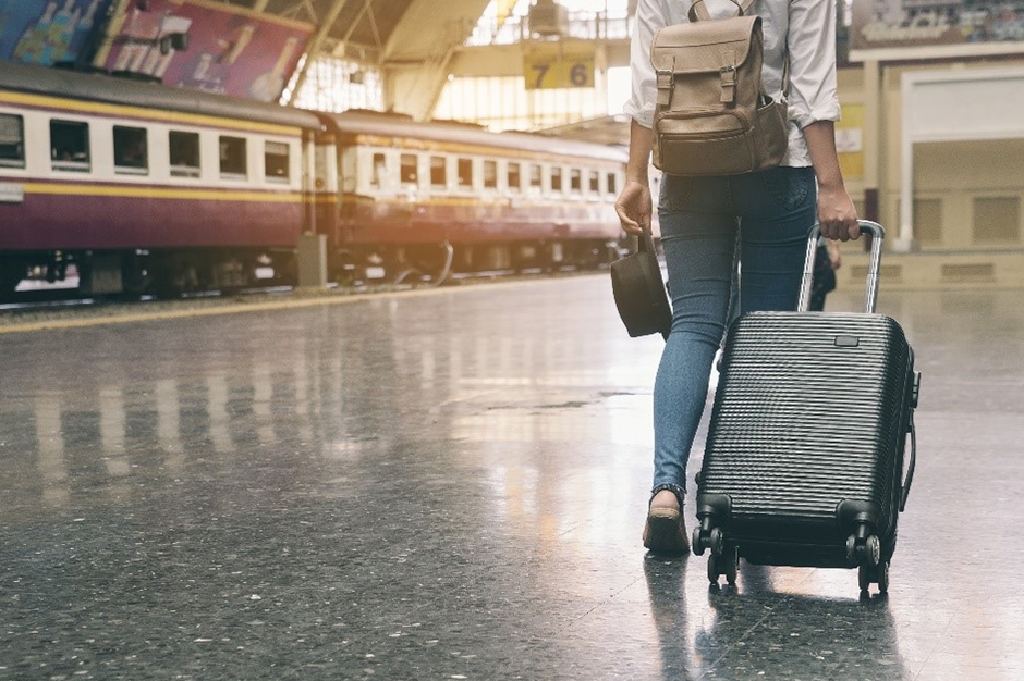 Walking through a train station with luggage.